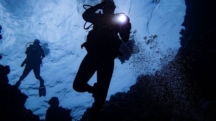 Scuba divers descending into a blue hole.