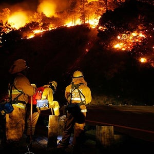 Firefighters keep watch as a California fire burns in 2007