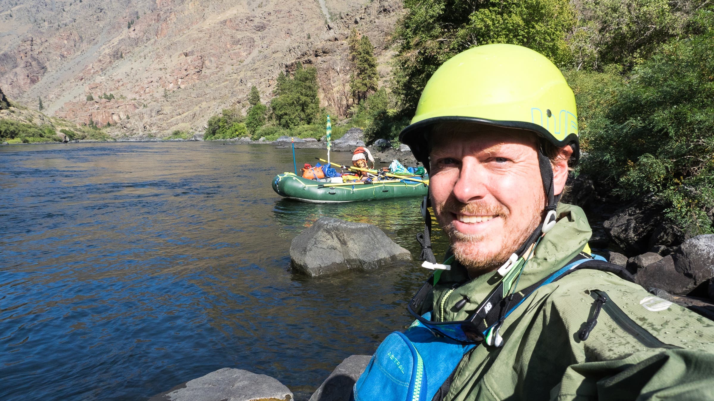 Man taking a selfie in a raft on a river.