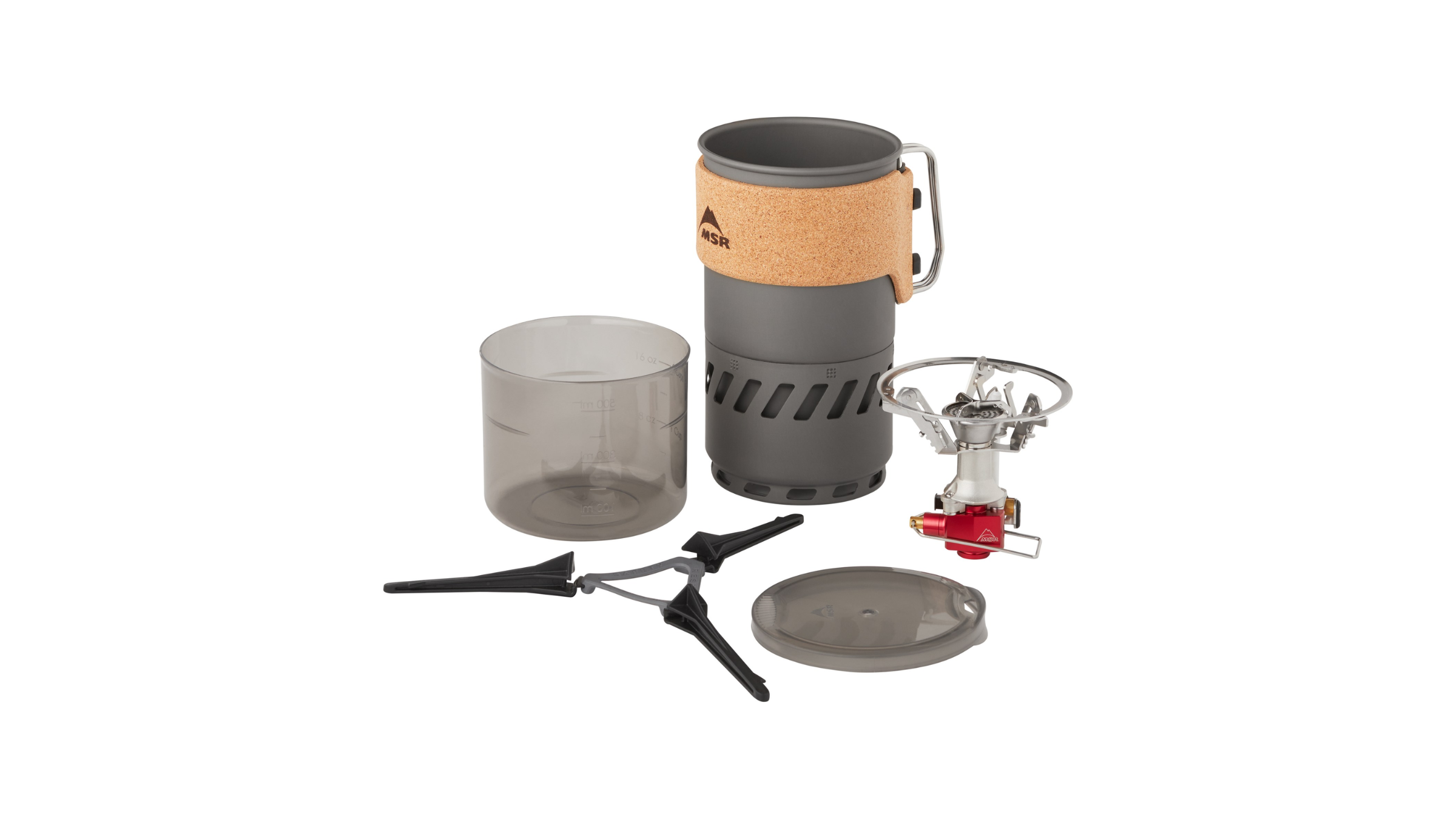 The components of an MSR backpacking stove system, including a burner, stabilizing tripod, measuring cup, and an insulated pot, are laid out to prepare hot water for camp coffee.