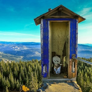 an outhouse with a mountain view