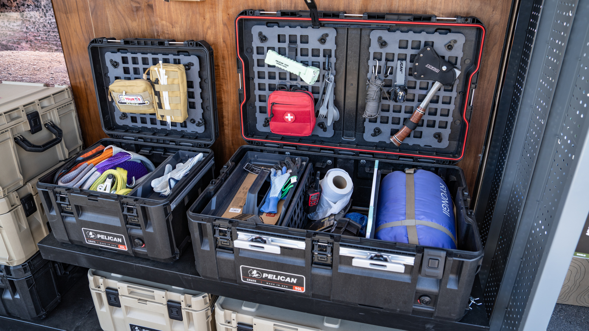two open large black Pelican crates packed with camping supplies outside at Overland Expo West