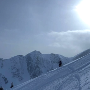 simon kearn hiking through a snow-packed mountain against a blue, clear sky