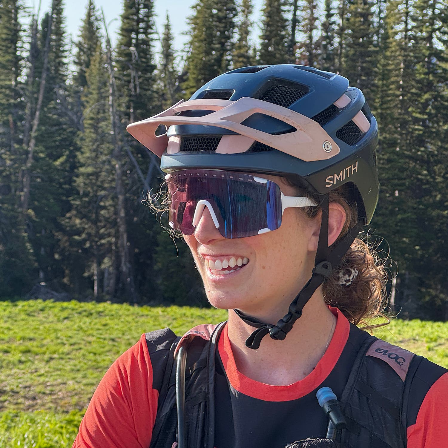 Mountain biker with helmet on wearing durable and breathable sports sunglasses on her ride.
