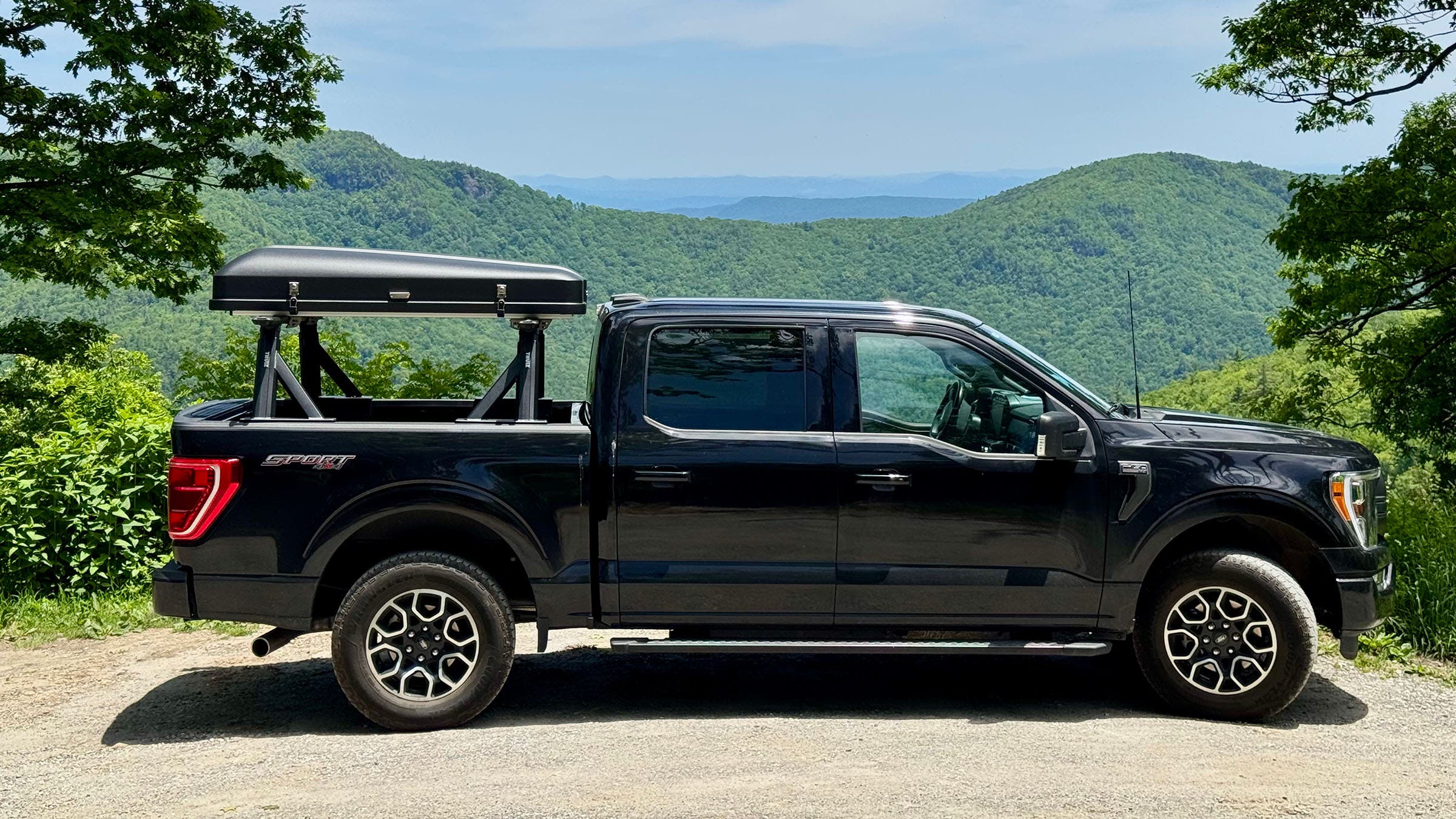 Black hardshell rooftop tent mounted on black truck 
