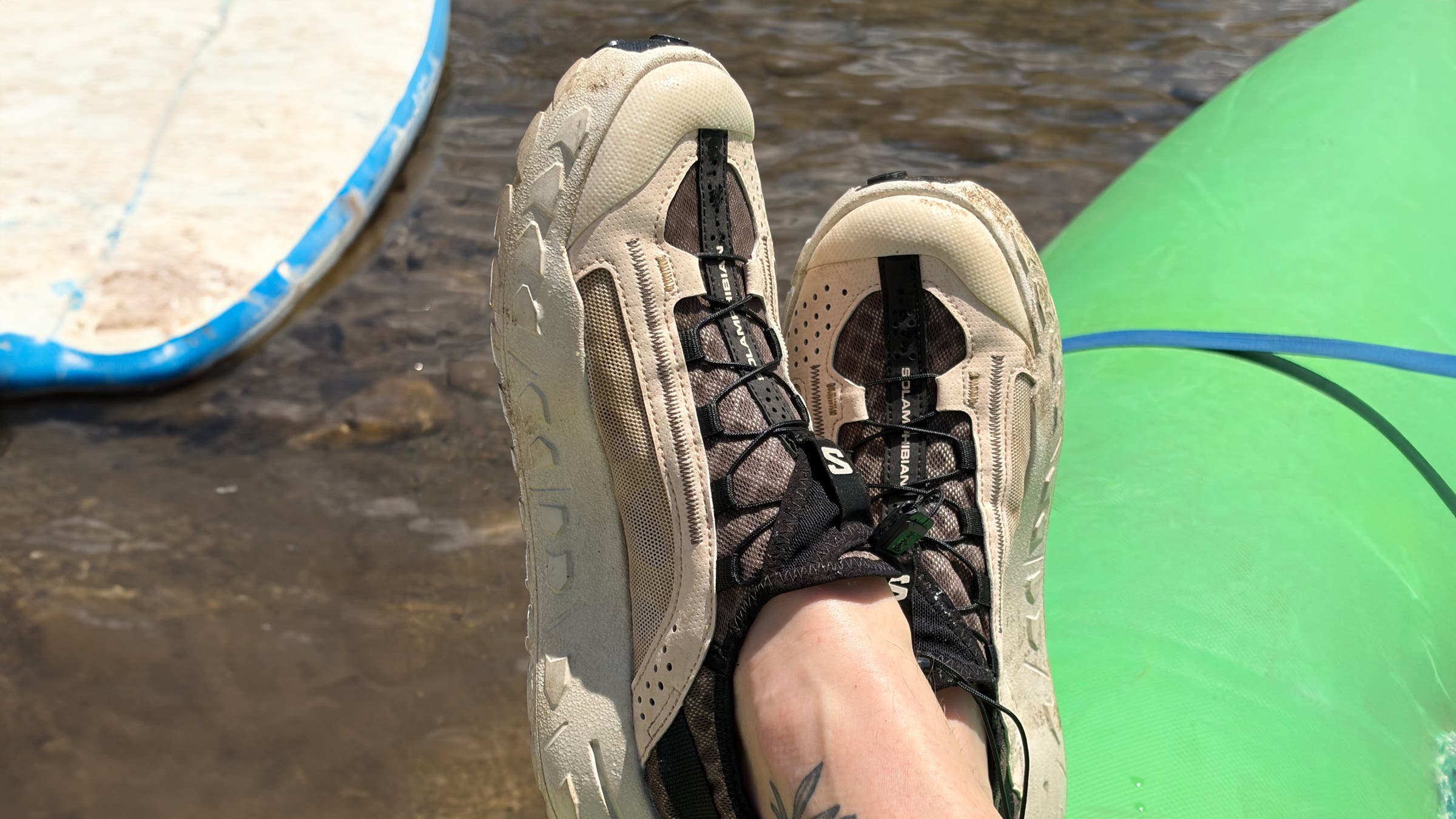 Salomon Solamphibian water sneakers resting on the edge of a rafting boat