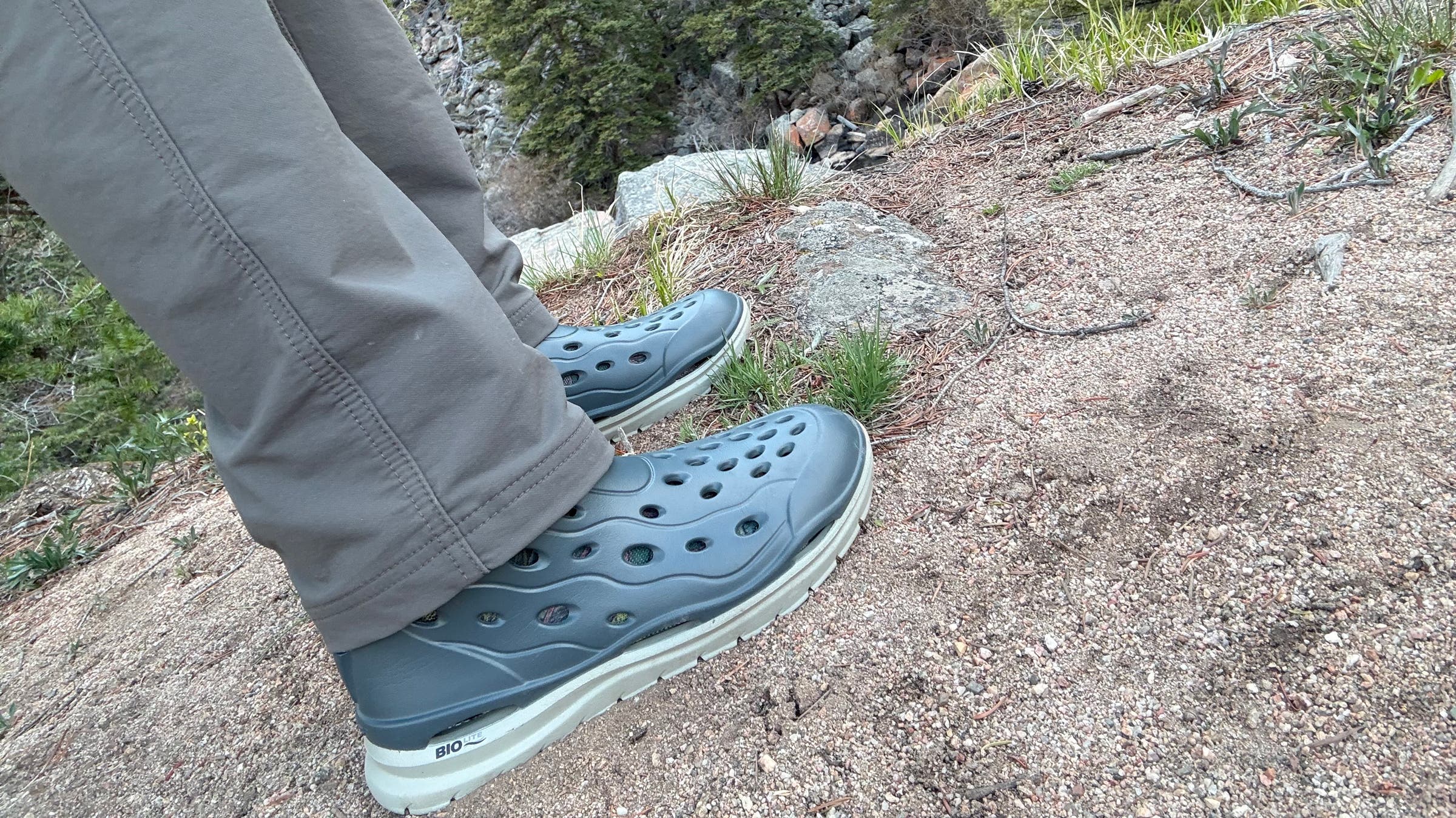 Tester hiking on bank of the river in Xtratuf Hightide water boots