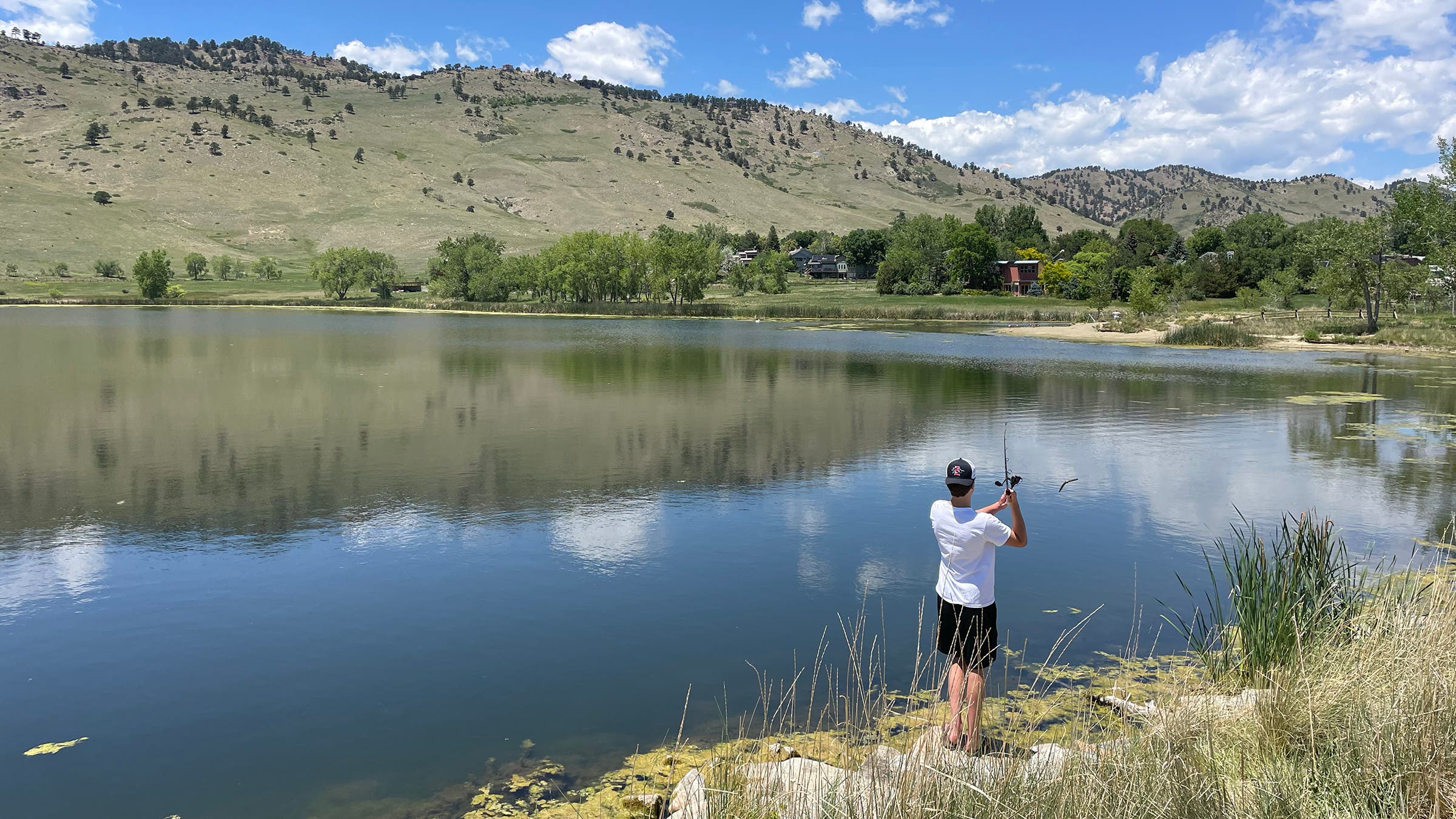 Teenage boy fishing at lake while camping with family