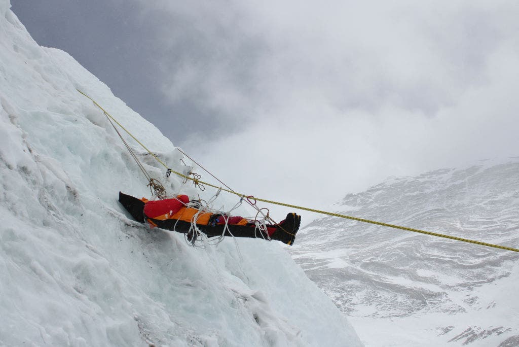 This picture taken on May 16, 2010 a corpse of a mountaineer being retrieved by unseen Nepalese sherpas during the Everest clean-up expedition