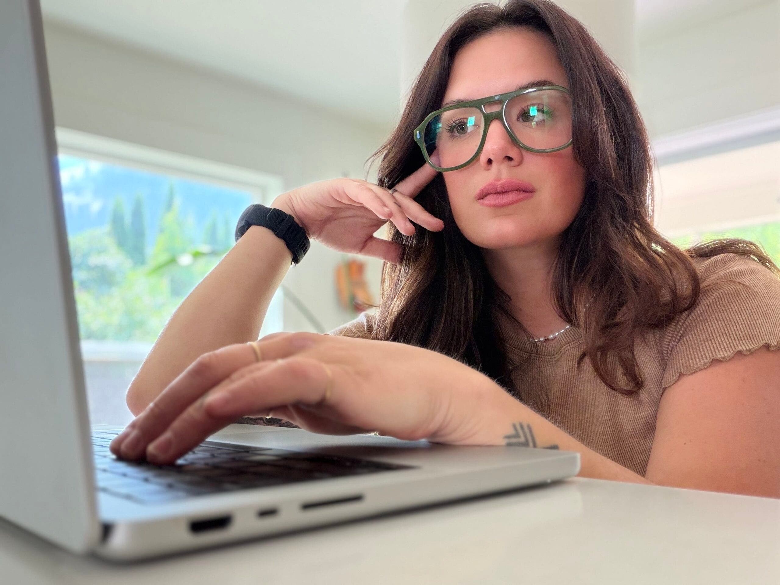 outside associate editor madison dapcevich working at her computer while wearing the jeremy jones x caddis glasses