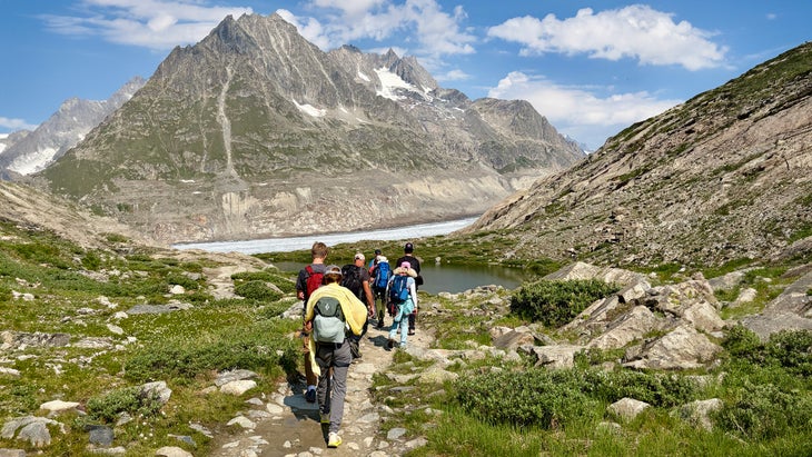 A group of hikers on day hike wearing day hiking backpacks on mountain trail