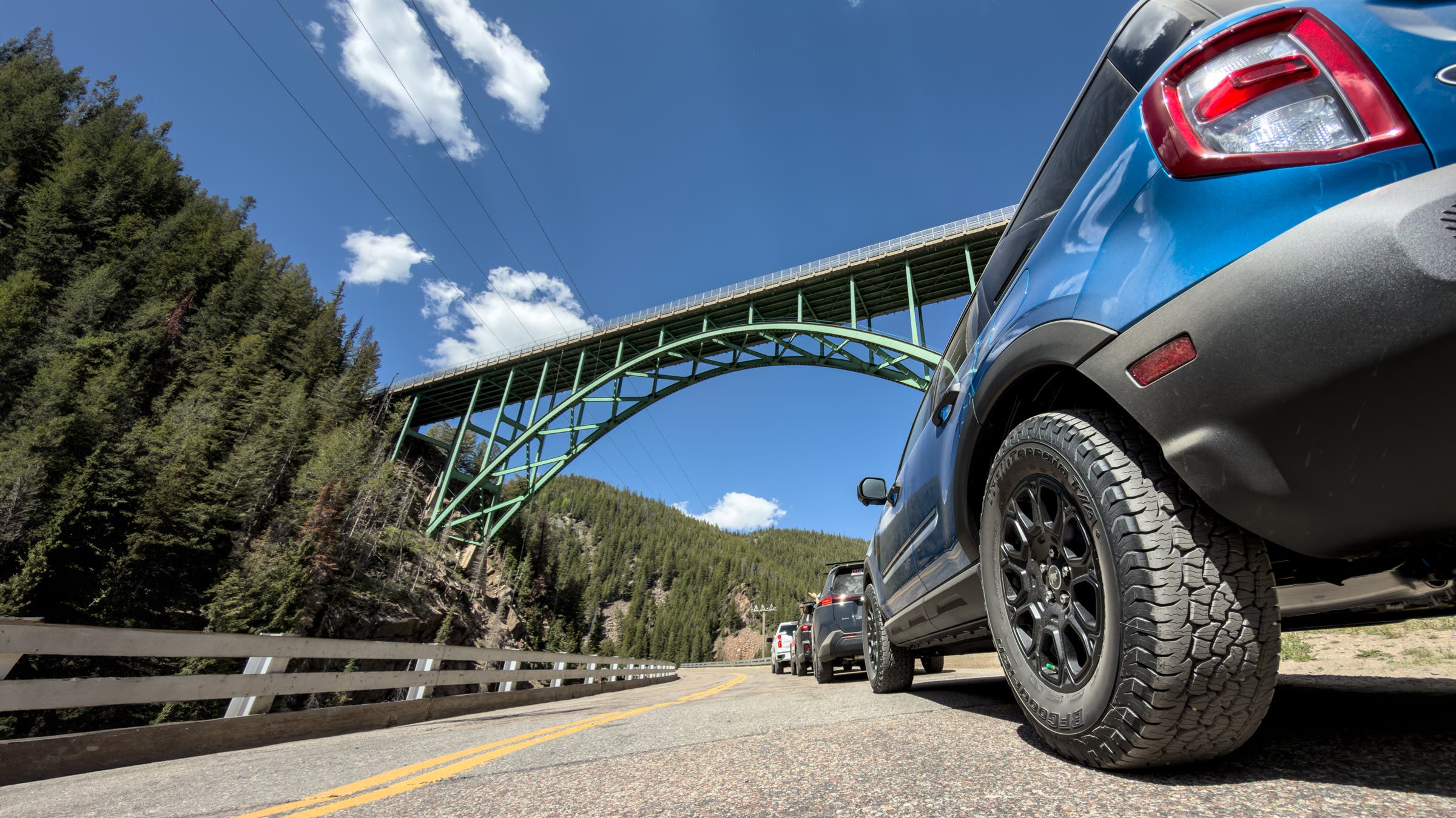 BF Goodrich Trail-Terrain T/A + off-road tire on Subaru Forrester driving on the road with bridge in view