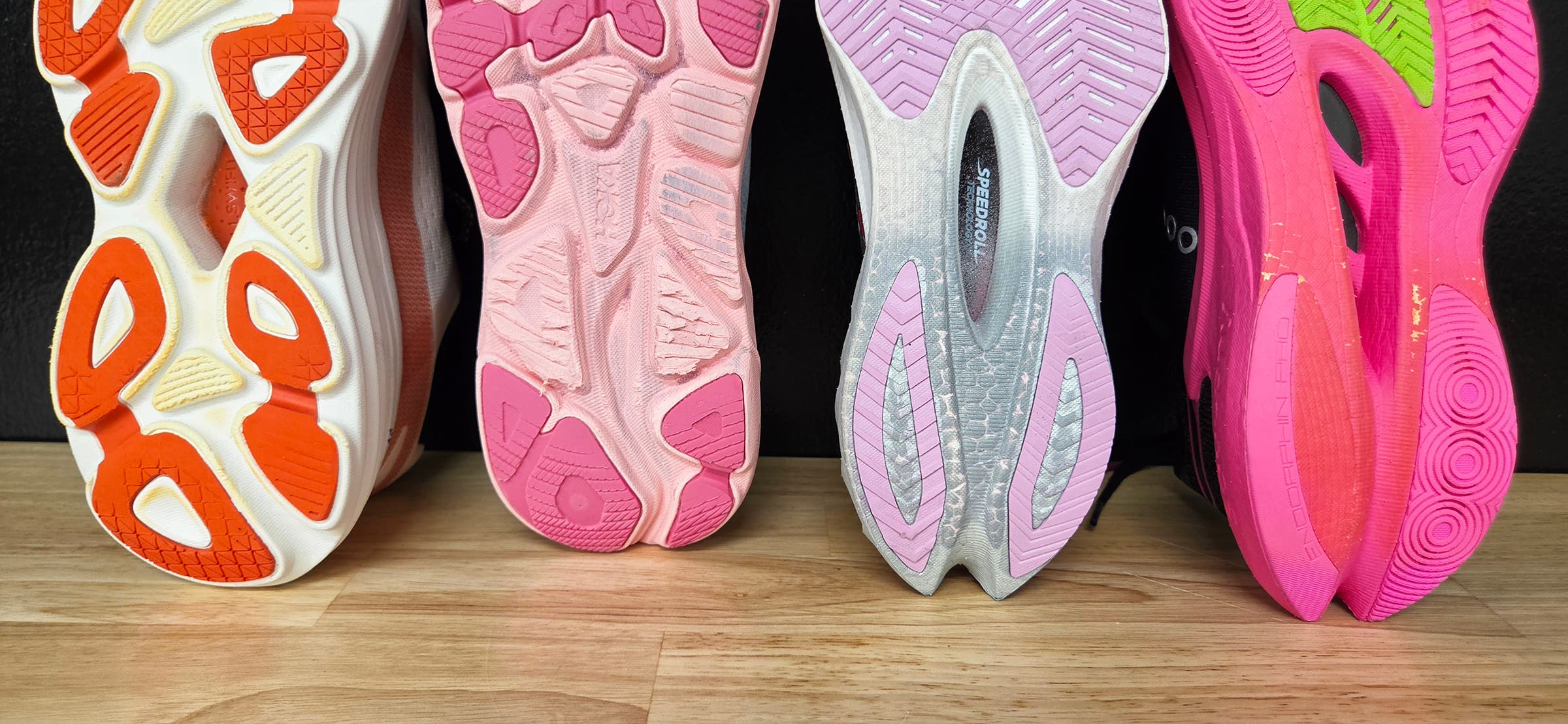Soles of 4 running shoes after being tested for durability