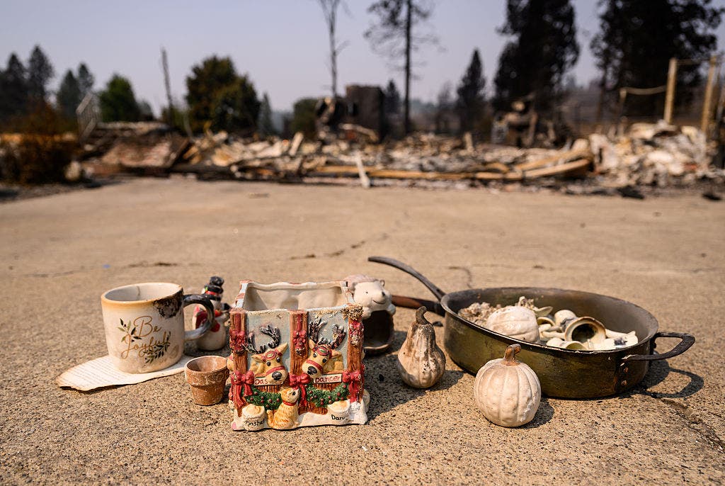 TOPSHOT - Recovered items are left on the driveway of a burned home during the Old Trails fire in Spokane, Washington on August 4, 2026. US authorities arrested a man on August 3, 2026 on suspicion of arson in connection with the biggest of three fires burning around the northwestern city of Spokane, as firefighters raced to contain flames that have displaced tens of thousands. Wildfires supercharged by drought and intense heat have torn through the city in Washington state, burning thousands of acres and reducing hundreds of buildings to cinders while anxious families await news on when they can return. (Photo by Josh Edelson / AFP via Getty Images)