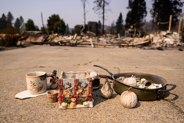 TOPSHOT - Recovered items are left on the driveway of a burned home during the Old Trails fire in Spokane, Washington on August 4, 2026. US authorities arrested a man on August 3, 2026 on suspicion of arson in connection with the biggest of three fires burning around the northwestern city of Spokane, as firefighters raced to contain flames that have displaced tens of thousands. Wildfires supercharged by drought and intense heat have torn through the city in Washington state, burning thousands of acres and reducing hundreds of buildings to cinders while anxious families await news on when they can return. (Photo by Josh Edelson / AFP via Getty Images) 