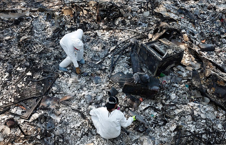 SPOKANE, WASHINGTON - AUGUST 05: Mark and David work to recover items from the remains of their mother Susan's home which was destroyed in the Old Trails Fire on August 5, 2026 in Spokane, Washington. Fueled by strong winds amid drought, fast-moving wildfires burned over 10,000 acres combined in the Spokane area over the weekend, destroying more than 700 structures, including many homes. 65,000 people were forced to evacuate, and one man was arrested on suspicion of first-degree arson in the Old Trails Fire. (Photo by Mario Tama/Getty Images