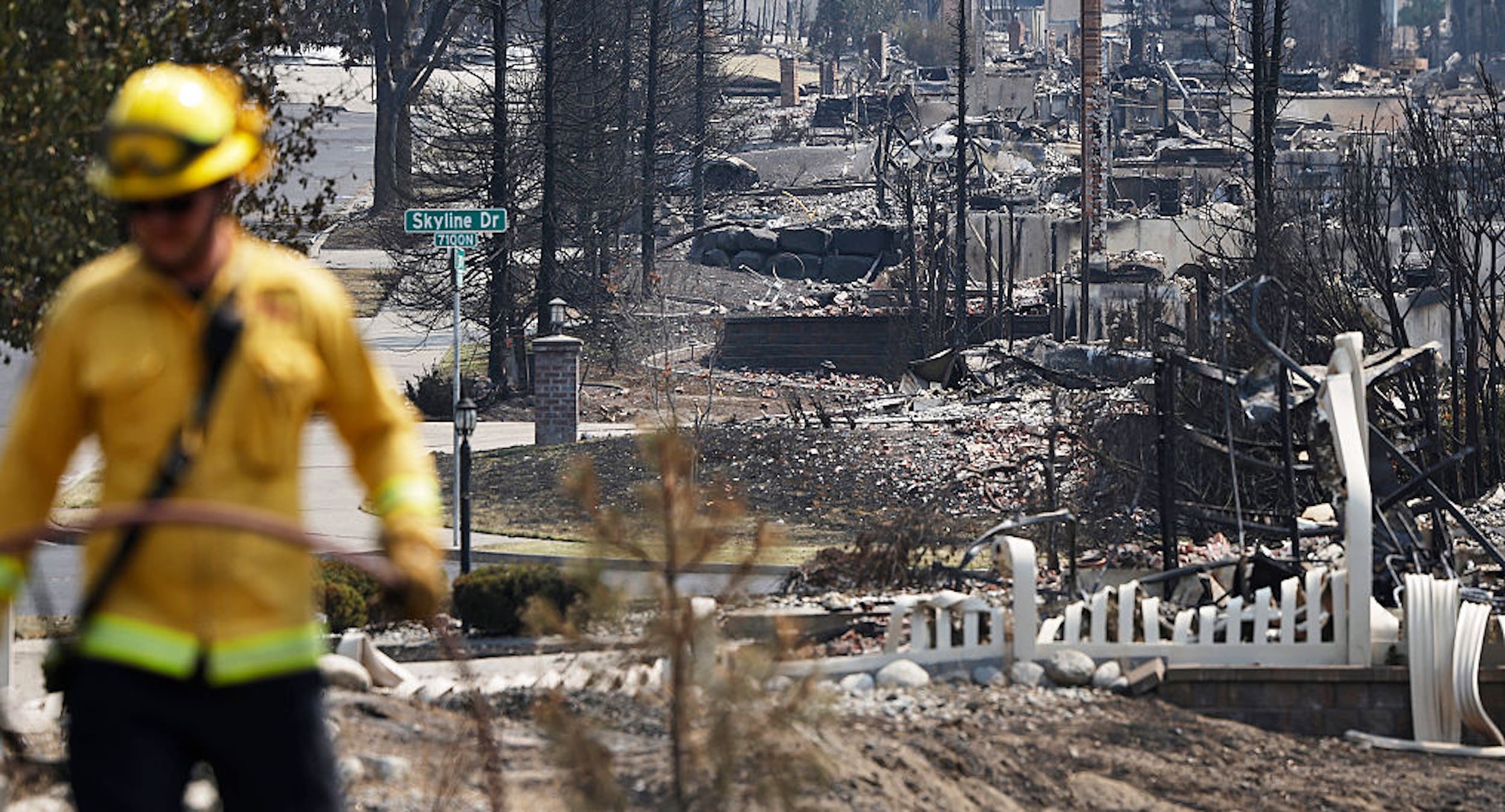 A Cal Fire firefighter works amid the remains of homes destroyed in the Old Trails Fire on August 6, 2026 in Spokane, Washington