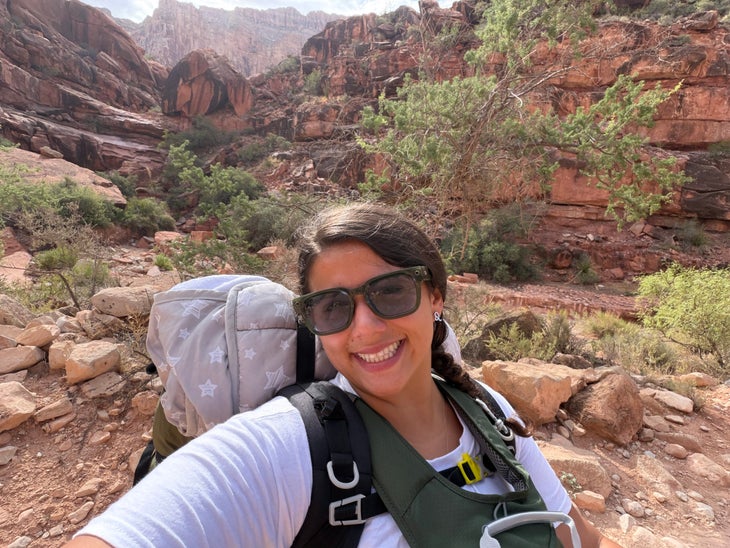 rowan shown backpacking, wearing her gear with the grand canyon in the background
