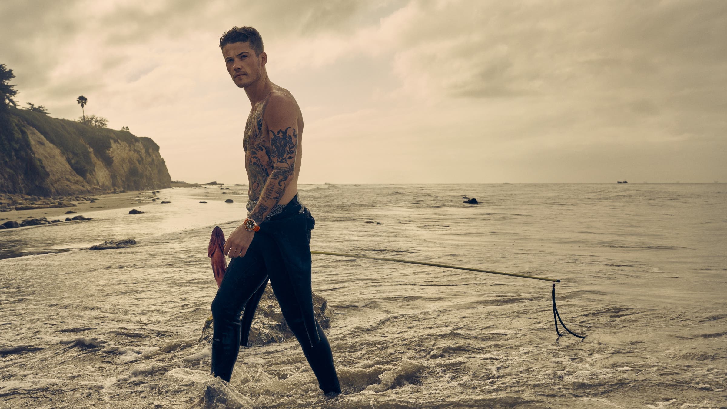 Aidan Owens walking out of the surf with a fish.