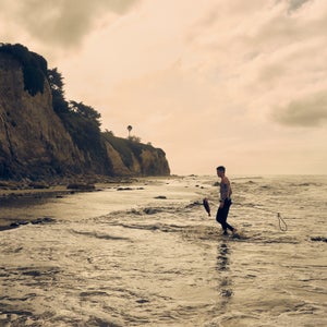 Aidan Owens walking out of the surf with a fish.