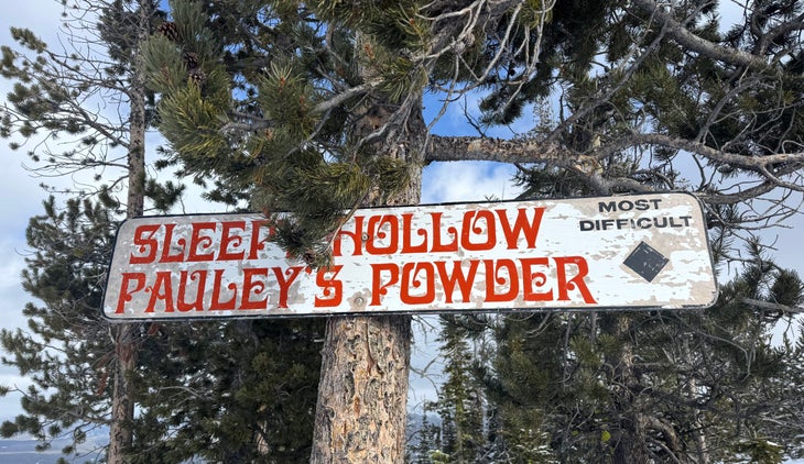 a sign shows the names of two ski runs, sleepy hollow and pauley's powder