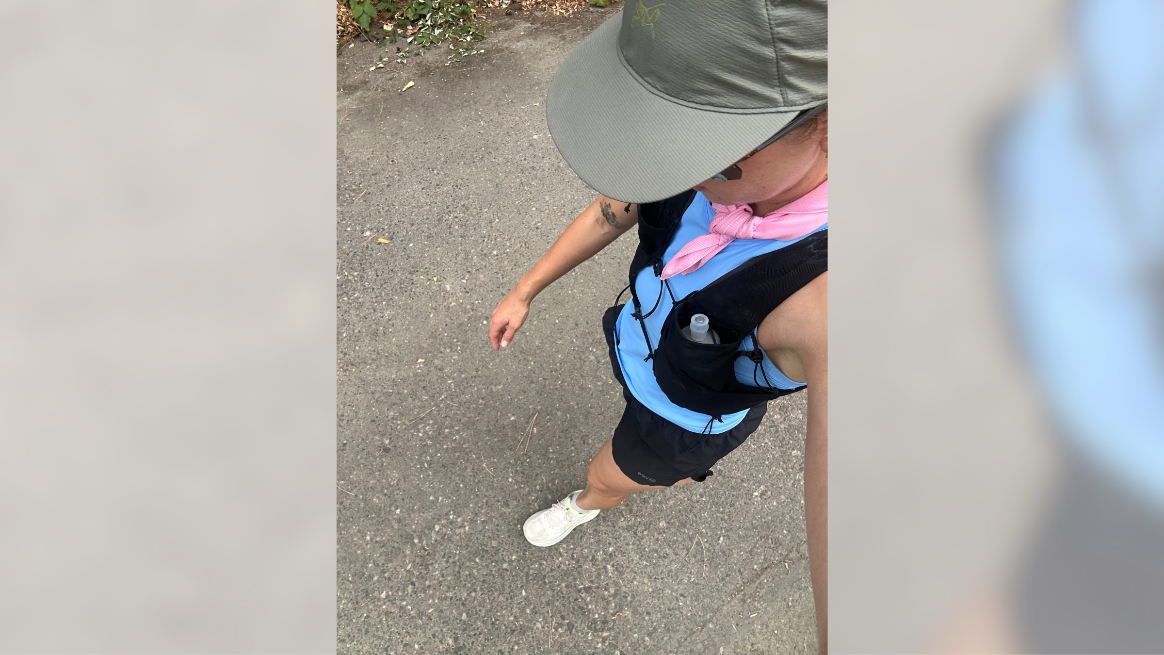 Top-down view of a runner field-testing the black Arc'teryx Norvan 7 running vest with a 500ml soft flask secured in the front chest pocket.