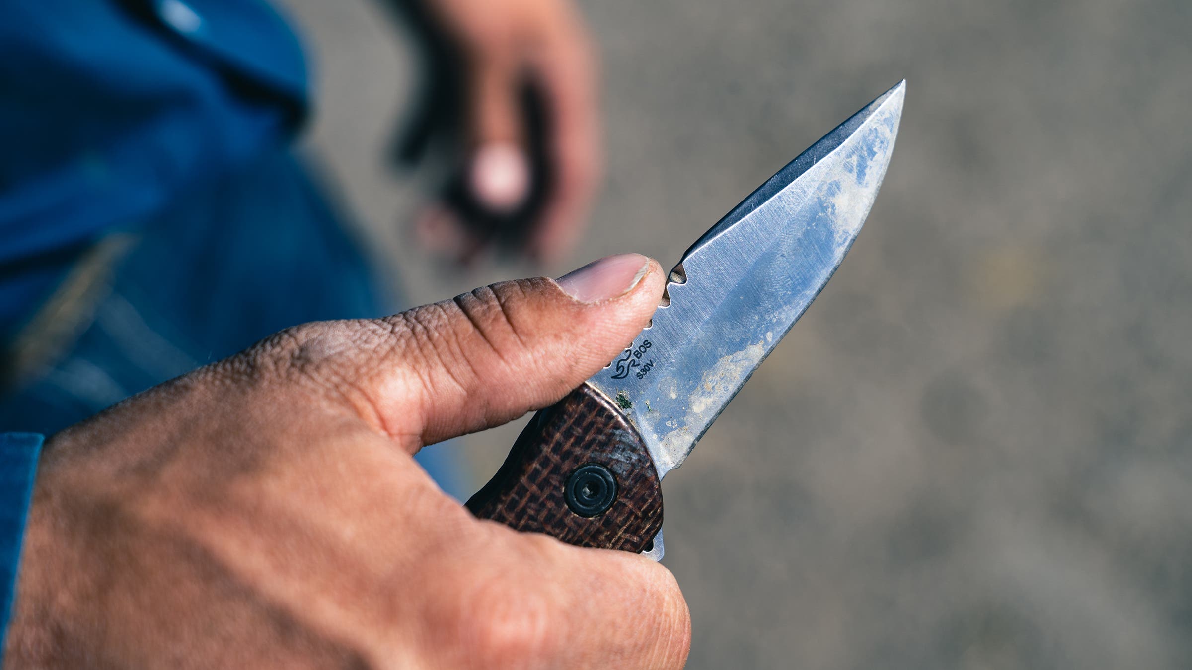 open Buck knife in rough workingman hand