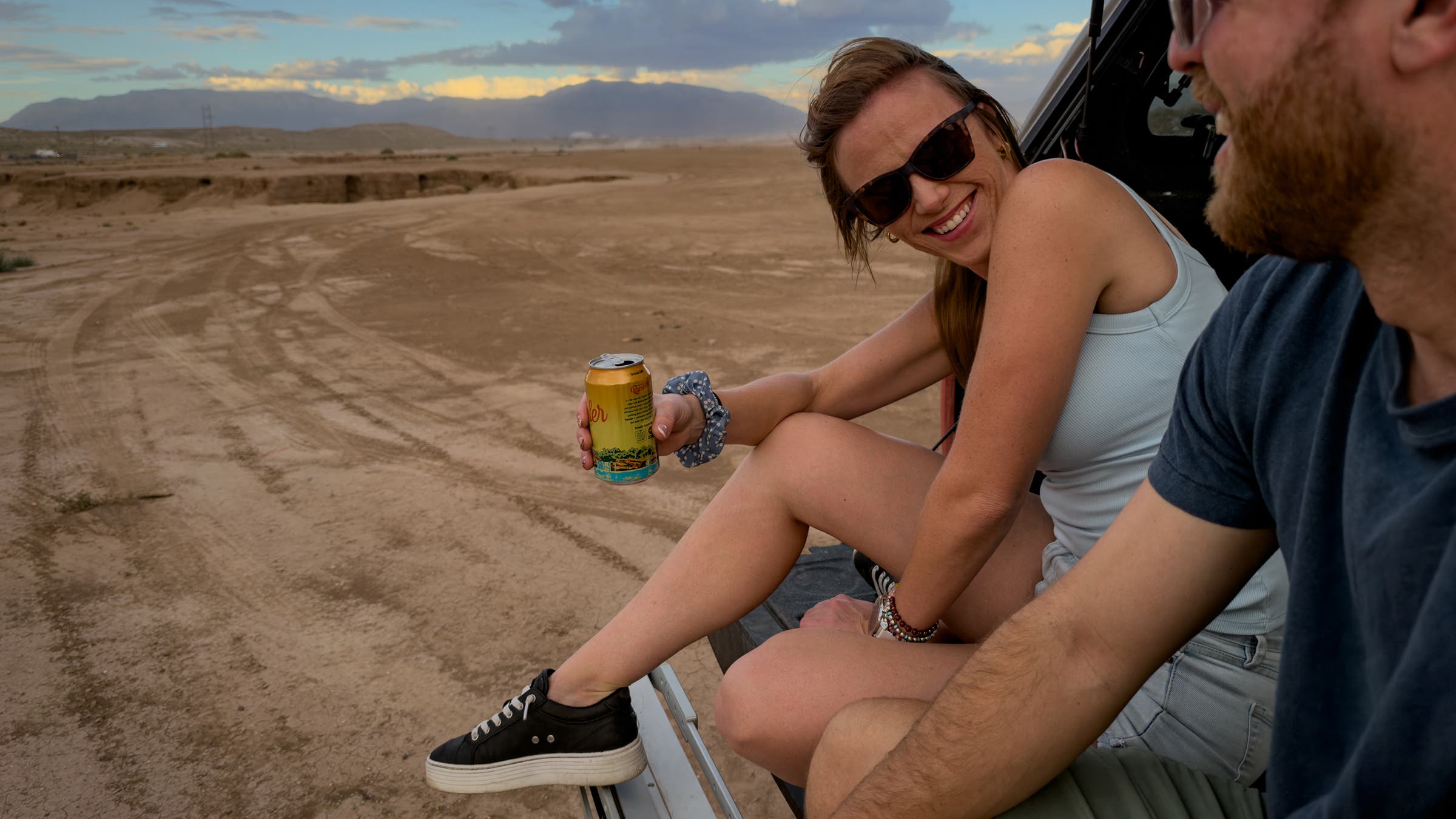 Woman and man on tailgate in the desert shot with iPhone 18 PRo