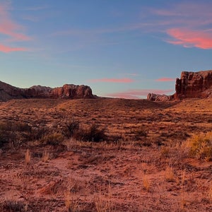 The skyline above Bluff, Utah, one of the most affordable climber towns in the country. A sunset can be seen above a red rock cliff.