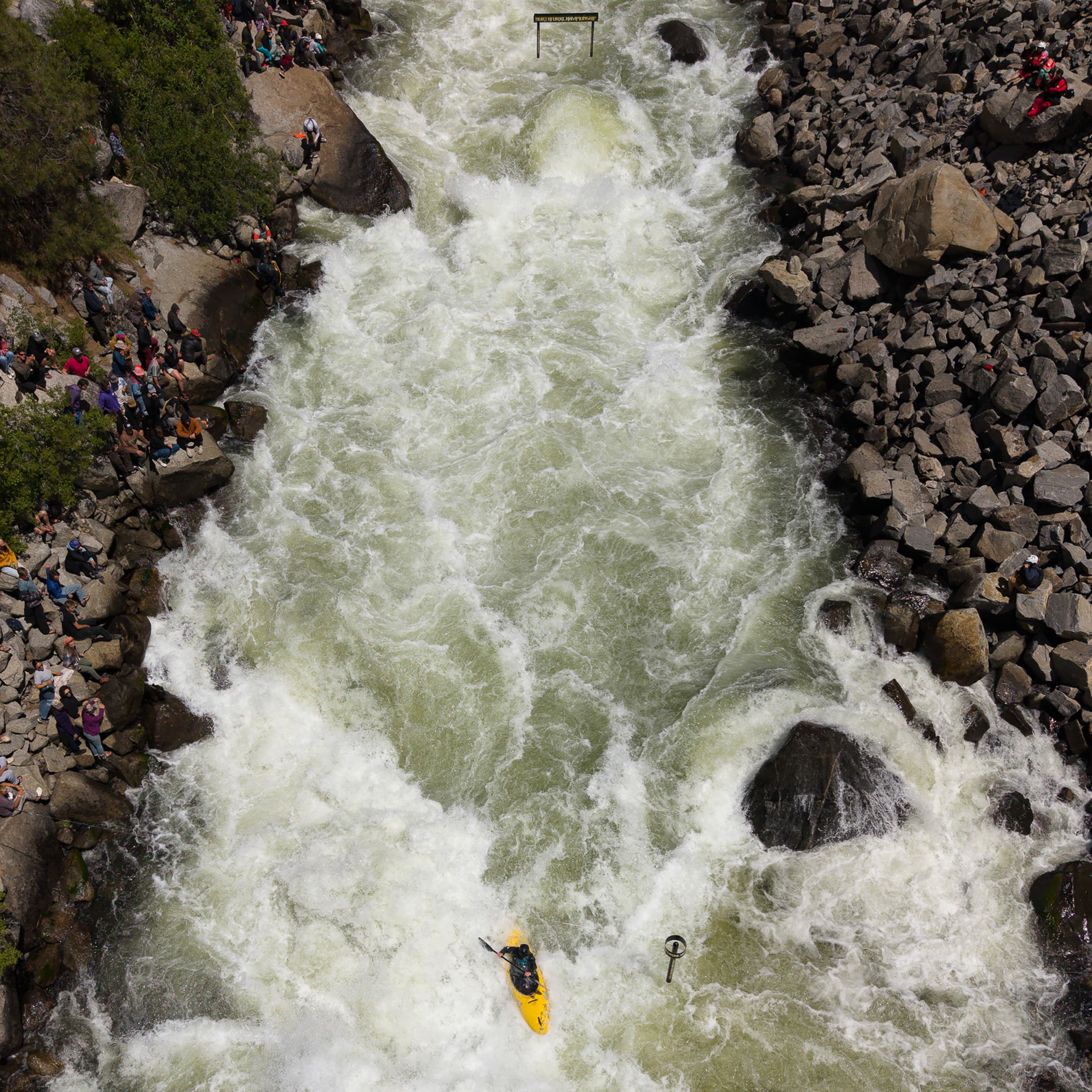 a kayaker in a yellow boat is photographed from an aerial view of the north fork payette river