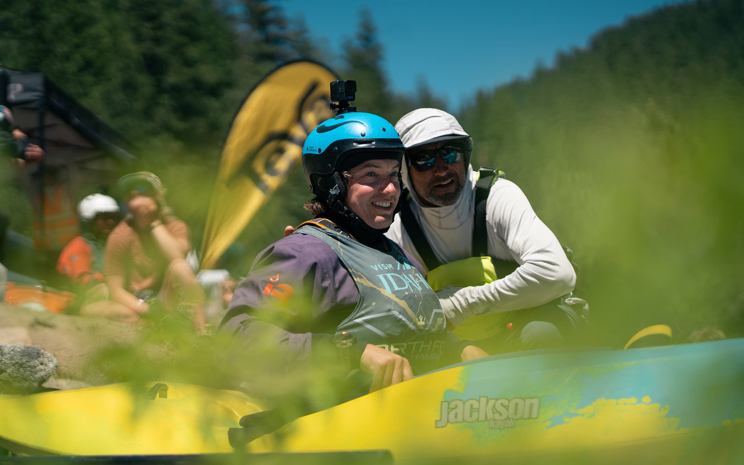 a kayaker is shown at the top of her run sitting in a yellow and blue boat