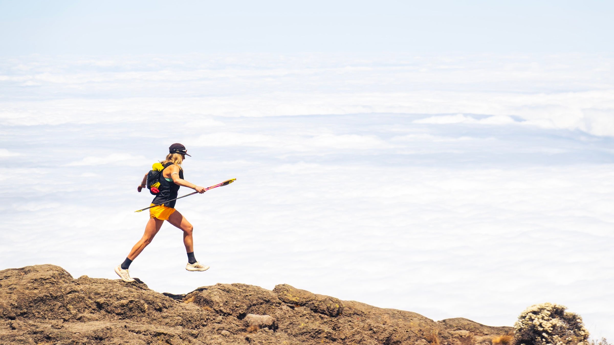 erin ton running atop mount kilimanjaro ith a cloudy white background