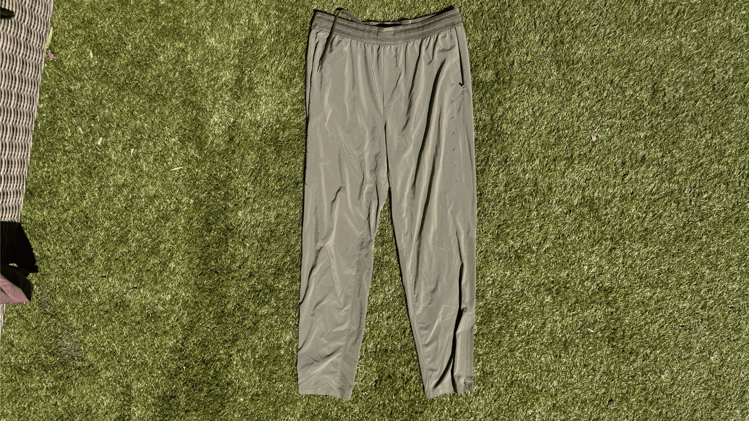 pair of olive green men's jogger pants from Ten Thousand lying flat on green turf