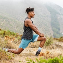 man stretching on scenic trail