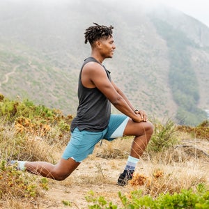 man stretching on scenic trail