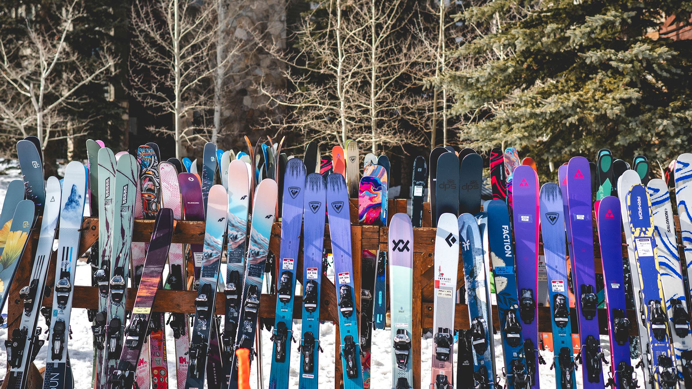 Colorful all-mountain skis lined up on rack at base area of 2026 SKI Test in Deer Valley