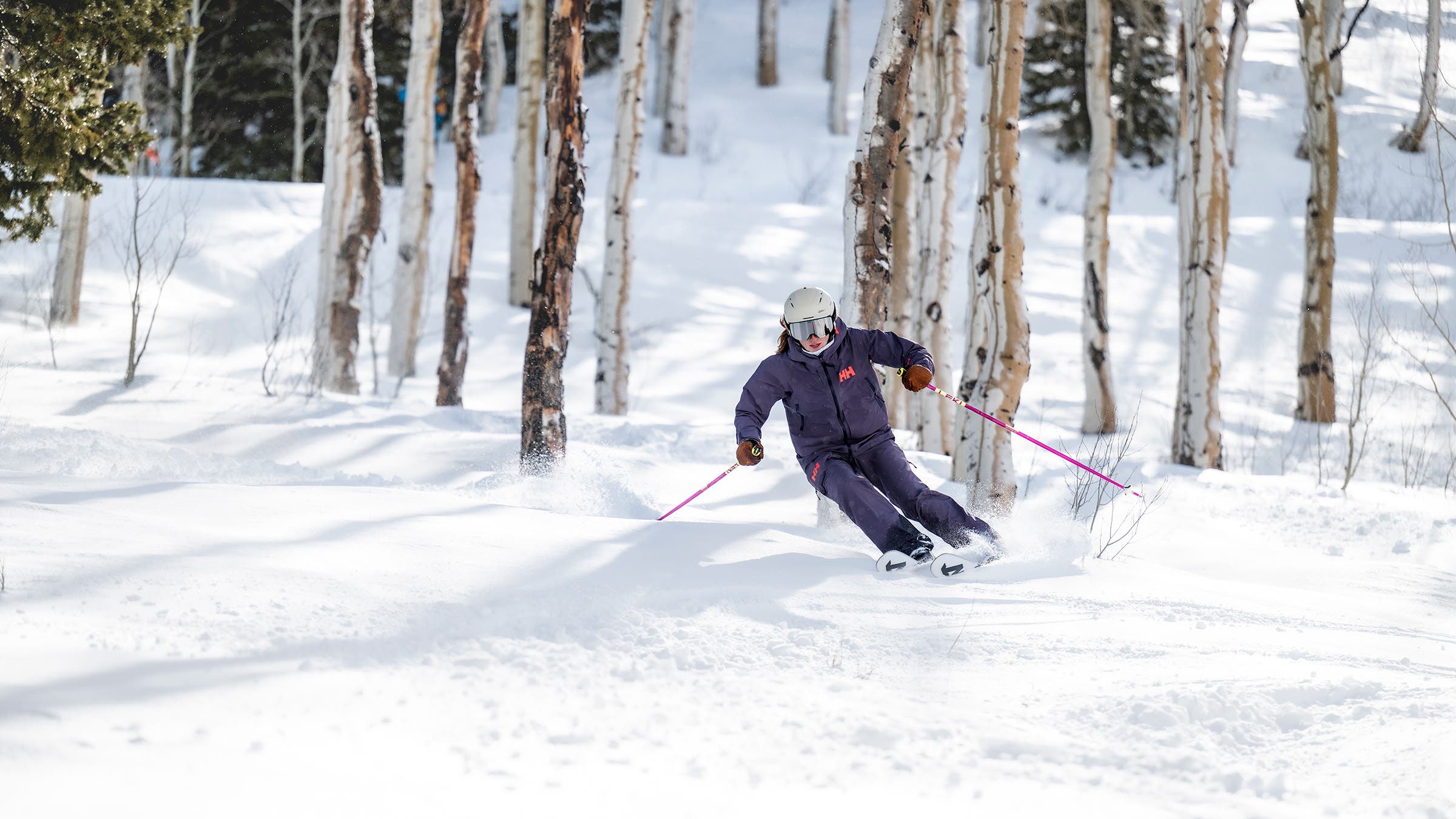 Skier in purple suit skiing Nordica ski through crud off-piste