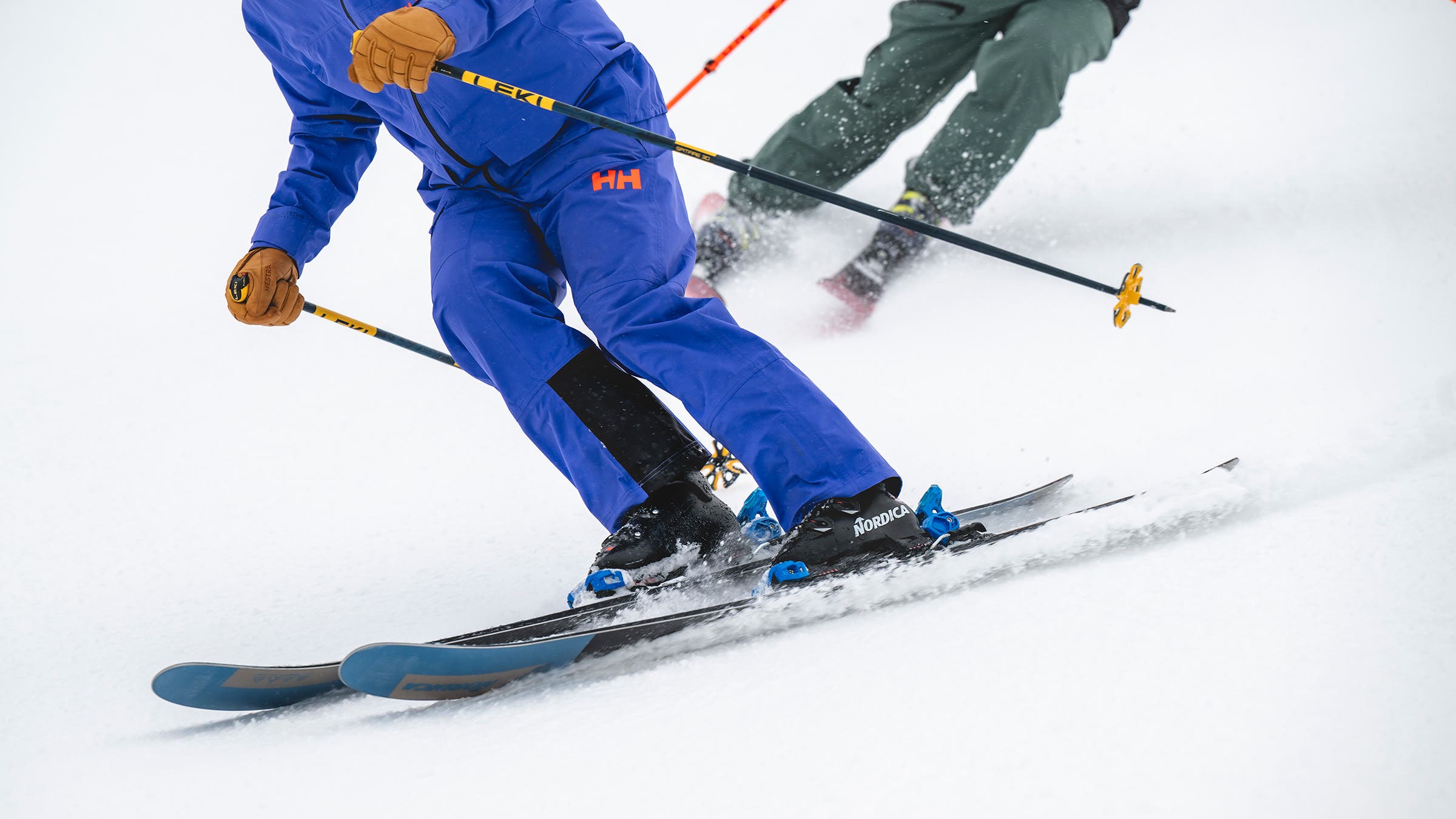 Closeup of lower body of skiers carving on Nordica Enforcer ski