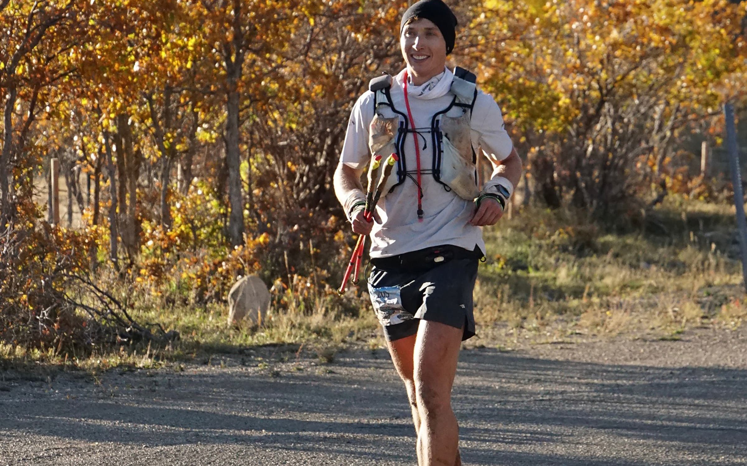 A runner runs past yellow trees
