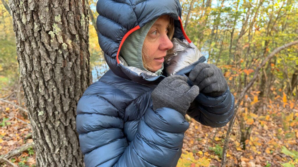 Tester zipping up a grey Rab Mythic G Down Jacket