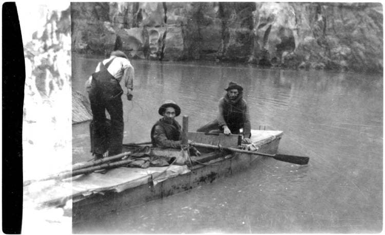 black and white photograph shows emery kolb sitting in a small wooden rowboat in the colorado river grand canyon