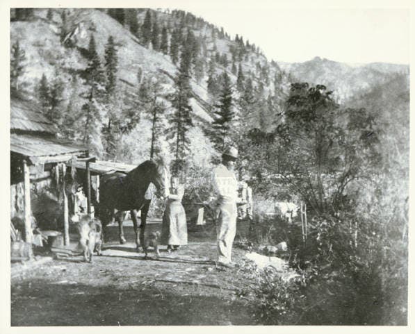 Charles and Polly Bemis standing in front of a cabin near Warren, Idaho