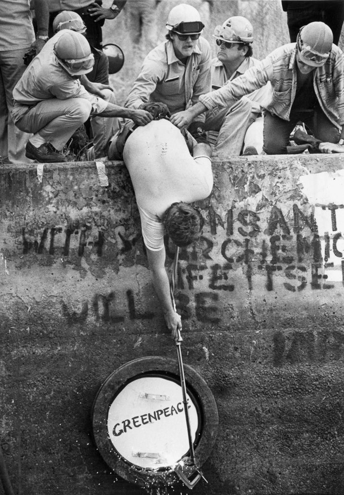 Monsanto workers removing a Greenpeace logo in 1983
