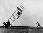 If you succeed try, try again: Orville Wright attempts to land a gilder at Kitty Hawk in 1911, while brother Lorin Wright and friend Alexander Ogilvie try, unsuccessfully, to keep it from flipping.