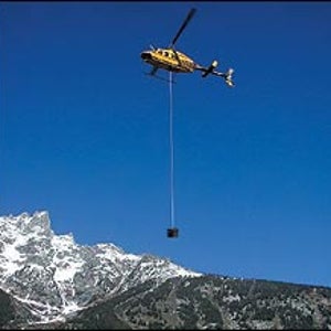 A park service chopper hoists a honey bucket out of the Tetons.
