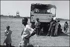 Refugees loiter around a supply truck.