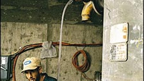 Slippery Hope: biodiesel entrepreneur Charris Ford (bottom), with colleague Nickolai Cowell, at work in their Colorado warehouse