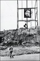 On the outskirts of Kabul, a boy waits beneath an image of the late Ahmed Shah Massoud.