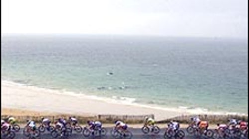 The peloton rode through rainy conditions past the Brittany shore during Saturday's Stage 7.