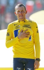 Lance Armstrong holds his hand on his chest as he listens to national anthems after winning his sixth straight Tour de France.